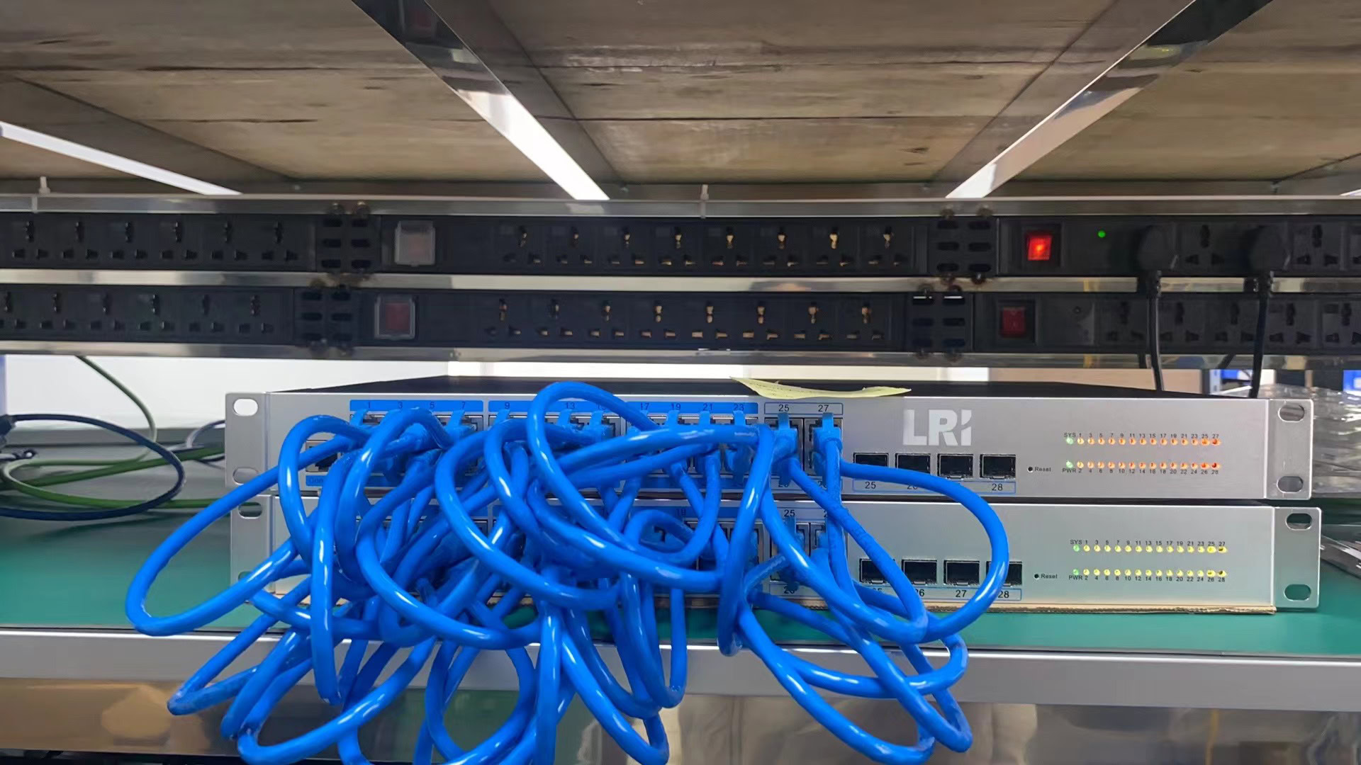 Conjunto de switches de automação industrial com cabos Ethernet azul conectados, utilizados para controle e monitoramento de sistemas industriais, promovendo eficiência e integração na automação.