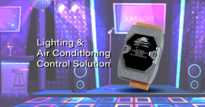 Dispositivo de controle de iluminação e ar condicionado em ambiente de evento musical, com palco iluminado, sistema de som e tela de karaokê ao fundo.